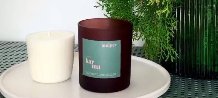 Load video: How to refill your Little Karma Co. candle glass in 3 easy steps. Firstly clean the glass with hot but not boiling water, trying to avoid the candle label wherever possible. Secondly, heat up the small area of wax on the bottom of the metal wick holder, this will hold the refill to the glass. Finally, pop the refill into the cleaned glass, press down gently and enjoy